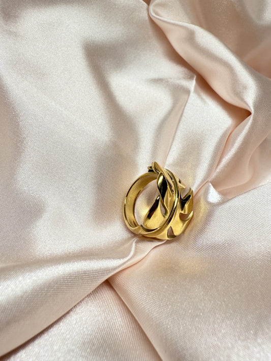 Gold ring on a soft pink fabric background