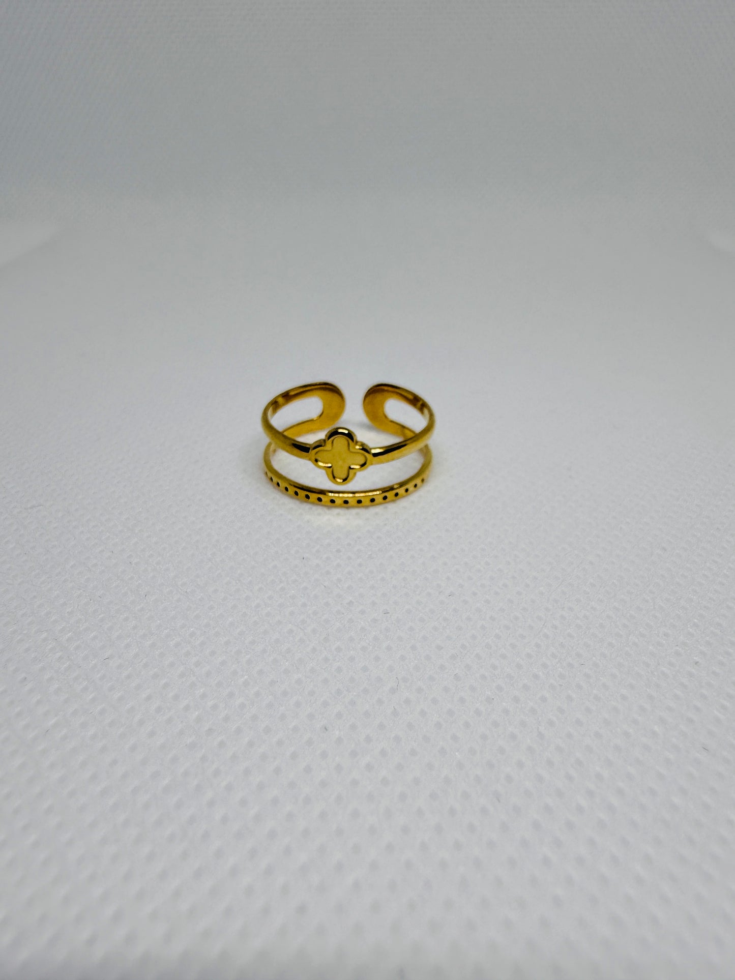Gold ring with a star design on a textured white background