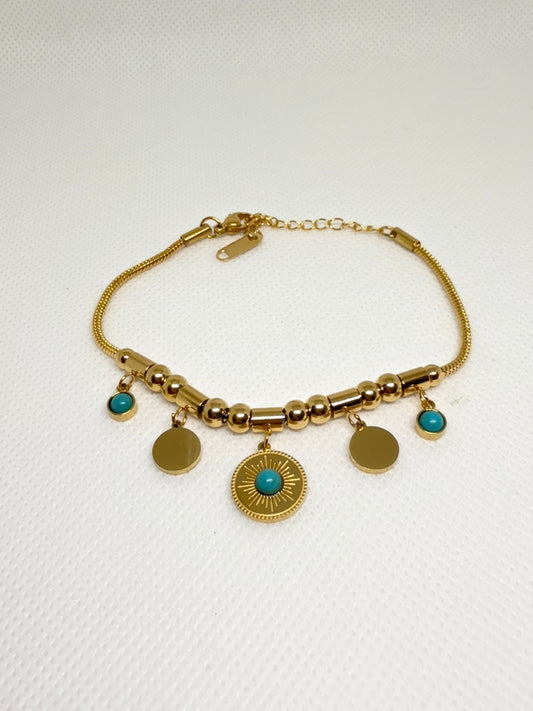 Gold bracelet with turquoise stones on a white background