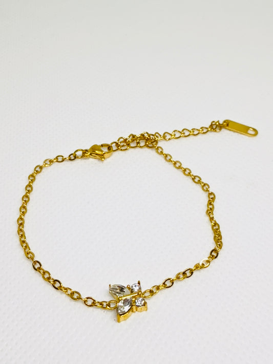 Gold bracelet with a butterfly charm on a white background