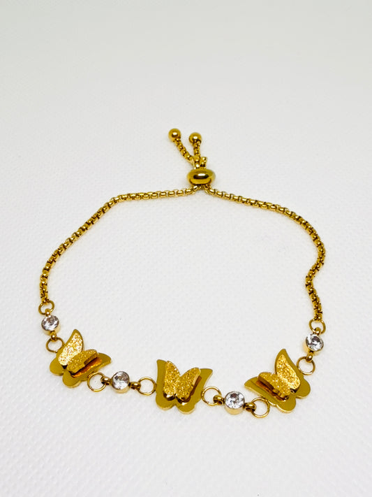 Gold bracelet with butterfly charms on a white background