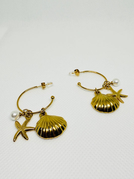 Gold hoop earrings with shell and starfish charms on a white background