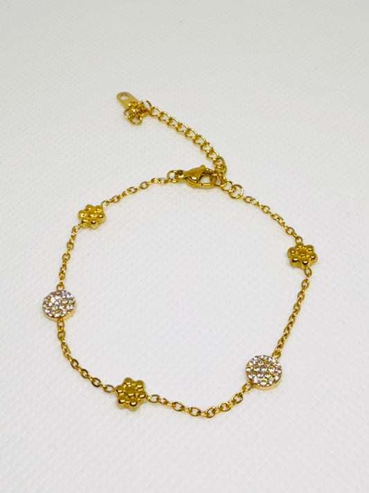 Gold bracelet with floral designs on a white background